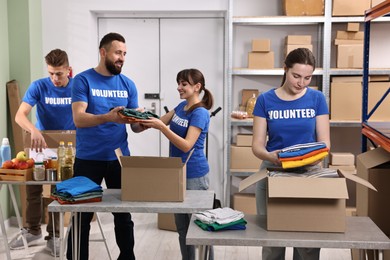 Photo of Group of volunteers packing donation goods at tables indoors