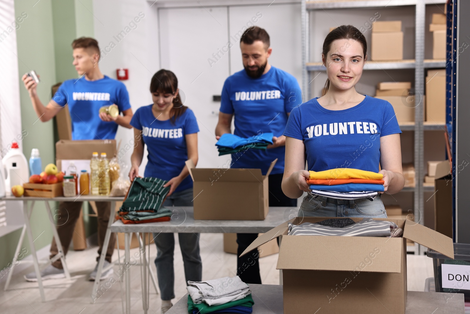 Photo of Group of volunteers packing donation goods at tables indoors