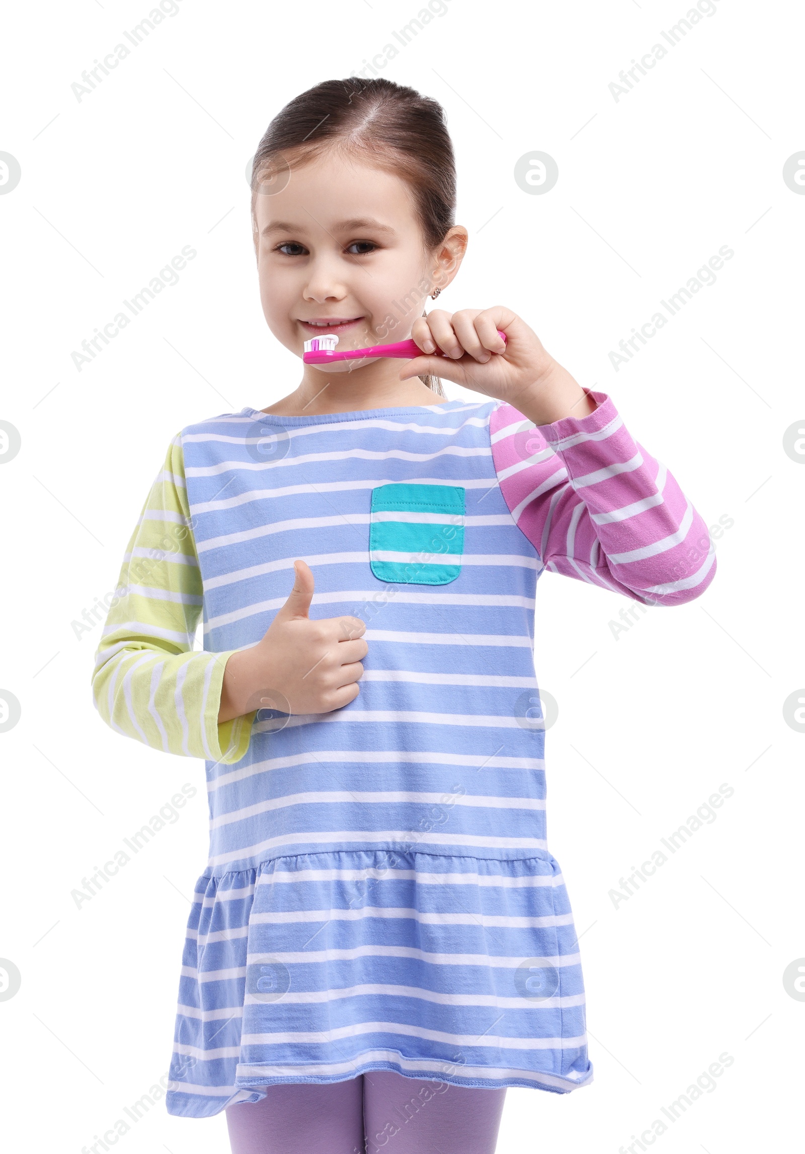 Photo of Cute girl brushing her teeth and showing thumbs up on white background