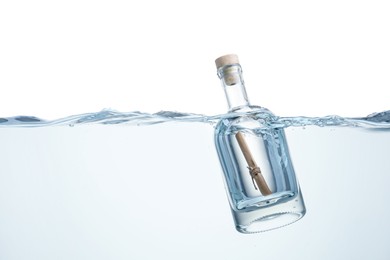 Photo of Corked glass bottle with rolled letter in water on white background