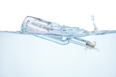 Photo of Corked glass bottle with rolled letter in water on white background