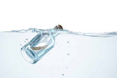 Photo of Corked glass bottle with rolled letter in water on white background