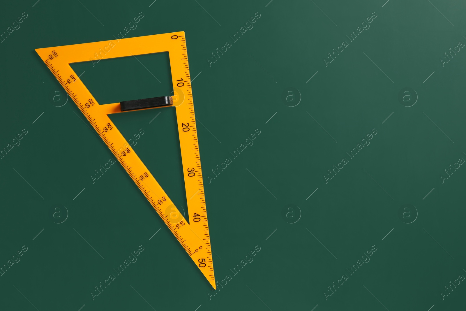 Photo of One triangle ruler on green chalkboard, top view. Space for text