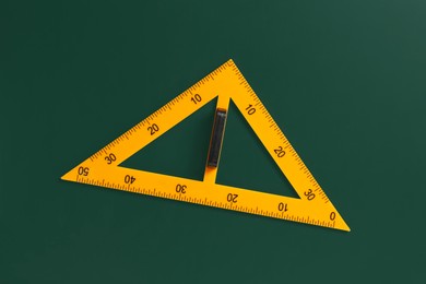 Photo of One triangle ruler on green chalkboard, top view