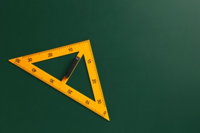 Photo of One triangle ruler on green chalkboard, top view. Space for text