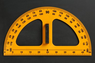 Photo of Protractor ruler on black chalkboard, top view