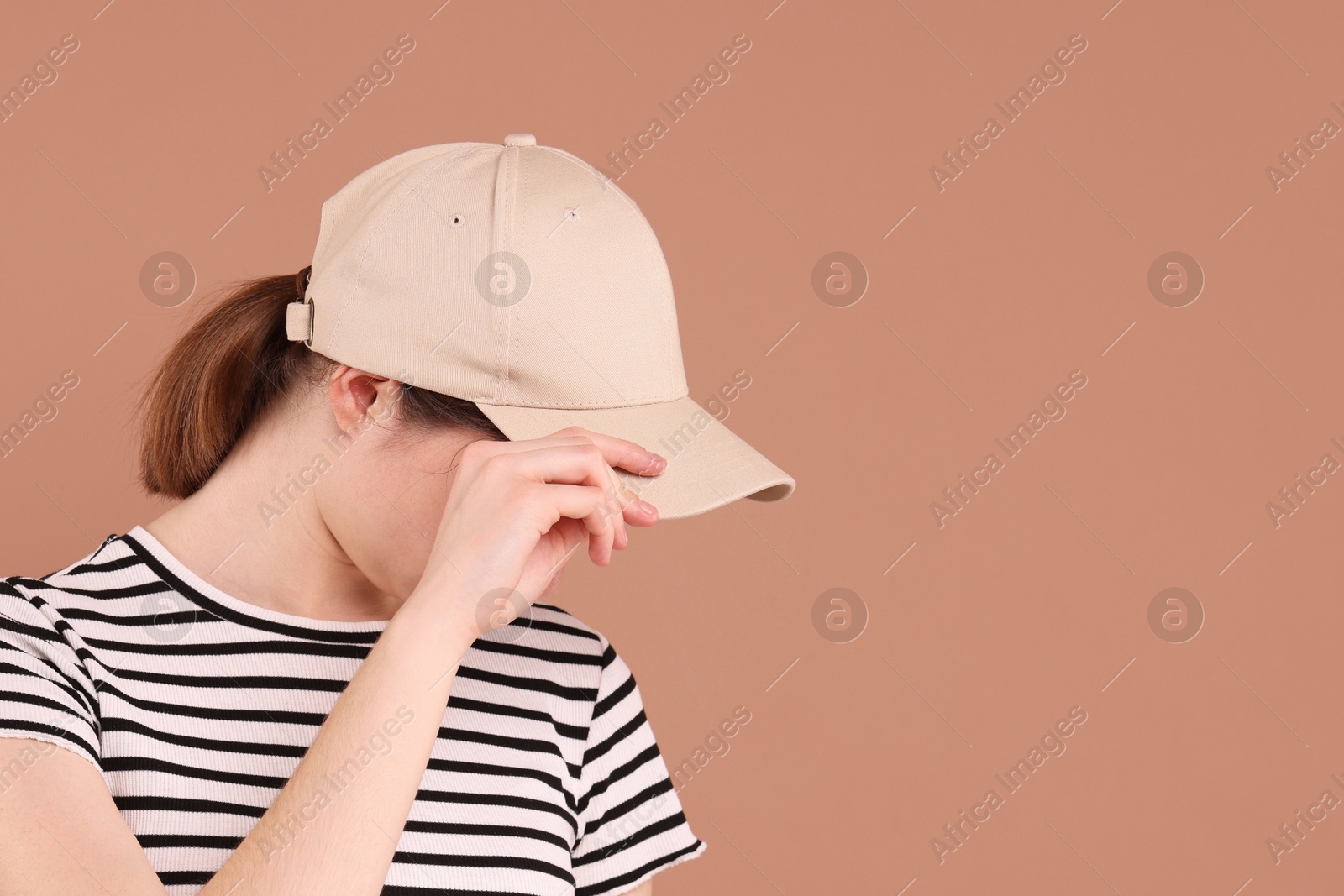 Photo of Woman in stylish baseball cap on beige background. Mockup for design