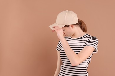 Photo of Woman in stylish baseball cap on beige background. Mockup for design