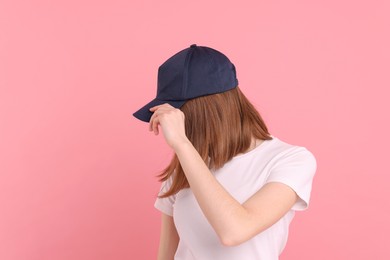 Photo of Woman in stylish baseball cap on pink background. Mockup for design