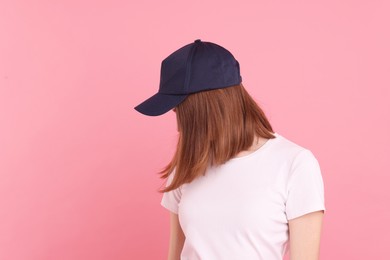 Photo of Woman in stylish baseball cap on pink background. Mockup for design