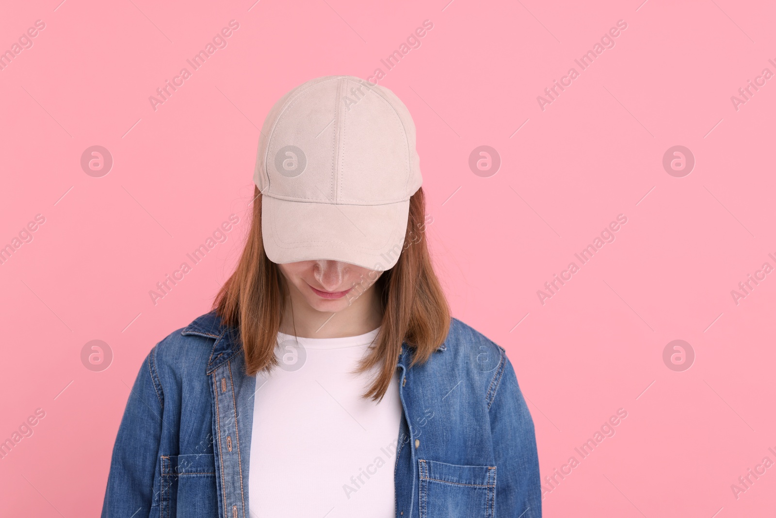 Photo of Woman in stylish baseball cap on pink background. Mockup for design