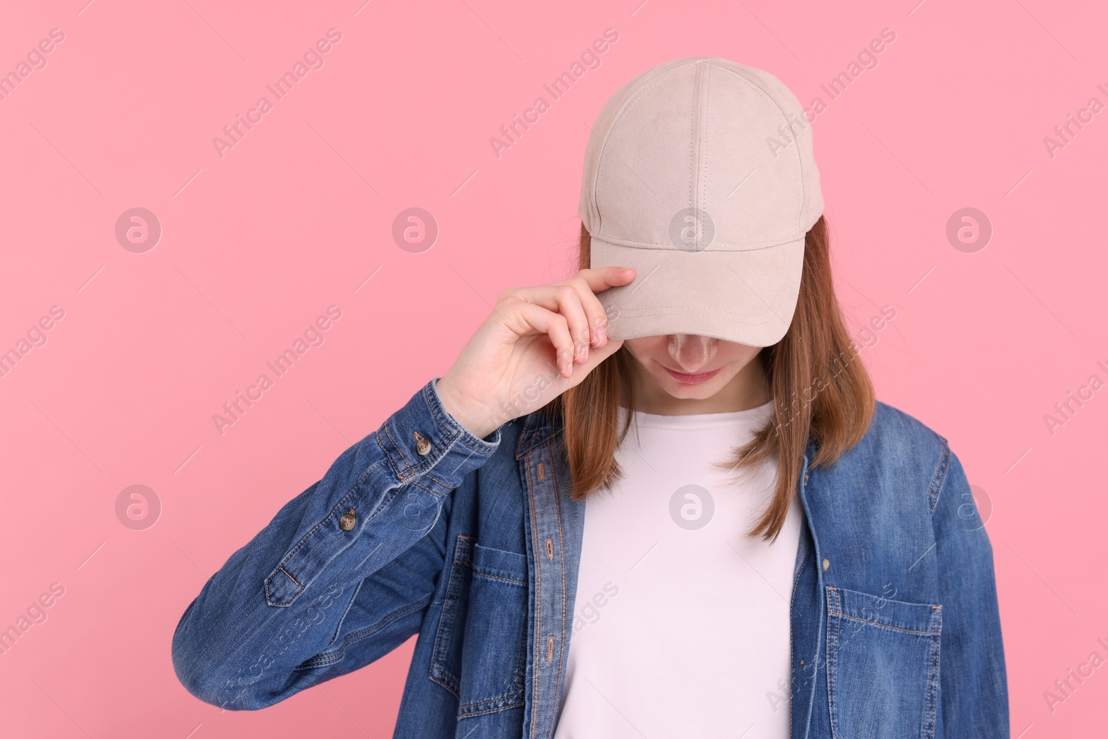 Photo of Woman in stylish baseball cap on pink background. Mockup for design