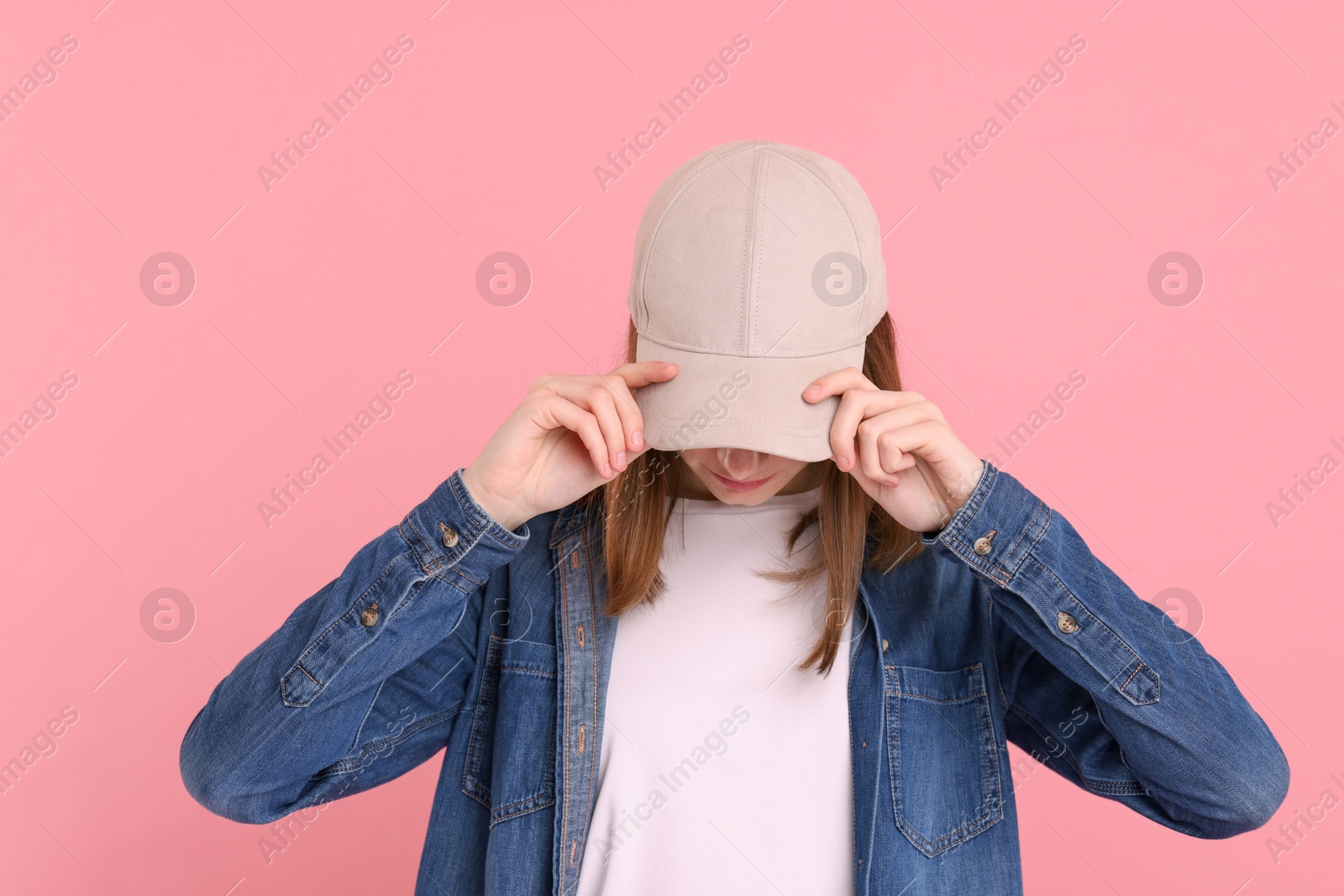 Photo of Woman in stylish baseball cap on pink background. Mockup for design