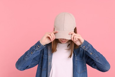 Photo of Woman in stylish baseball cap on pink background. Mockup for design