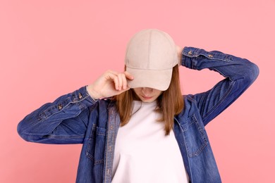 Photo of Woman in stylish baseball cap on pink background. Mockup for design