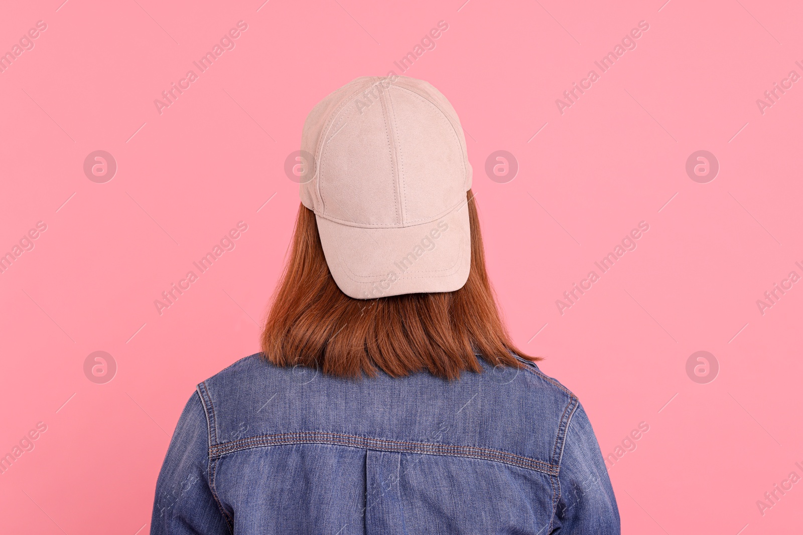 Photo of Woman in stylish baseball cap on pink background, back view. Mockup for design