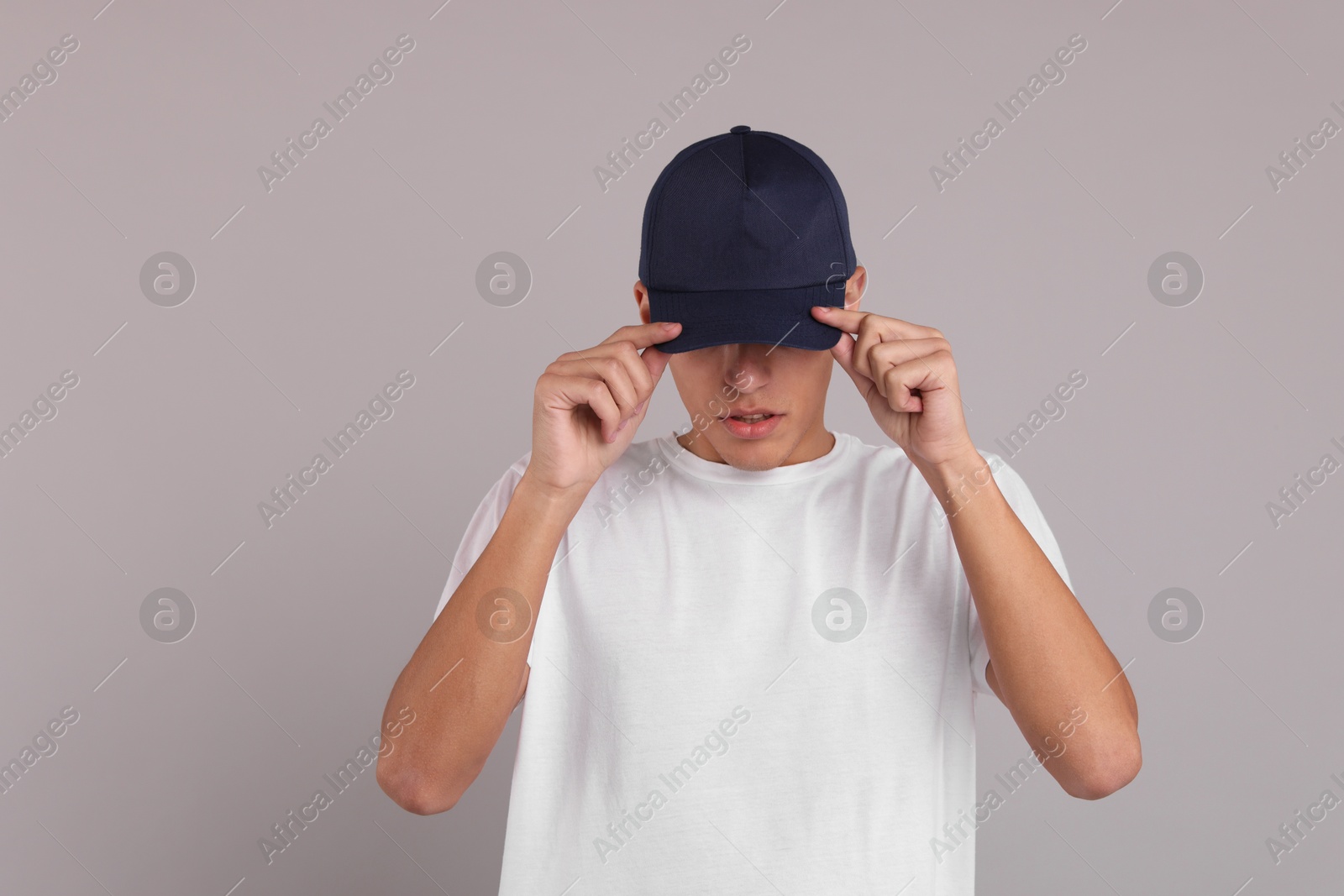 Photo of Man in stylish baseball cap on grey background. Mockup for design