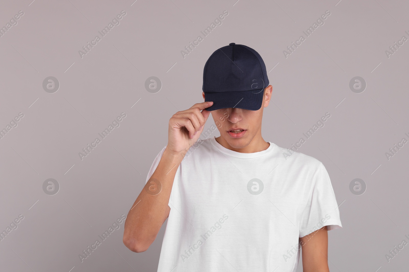 Photo of Man in stylish baseball cap on grey background. Mockup for design