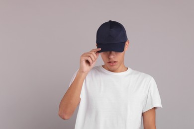 Photo of Man in stylish baseball cap on grey background. Mockup for design