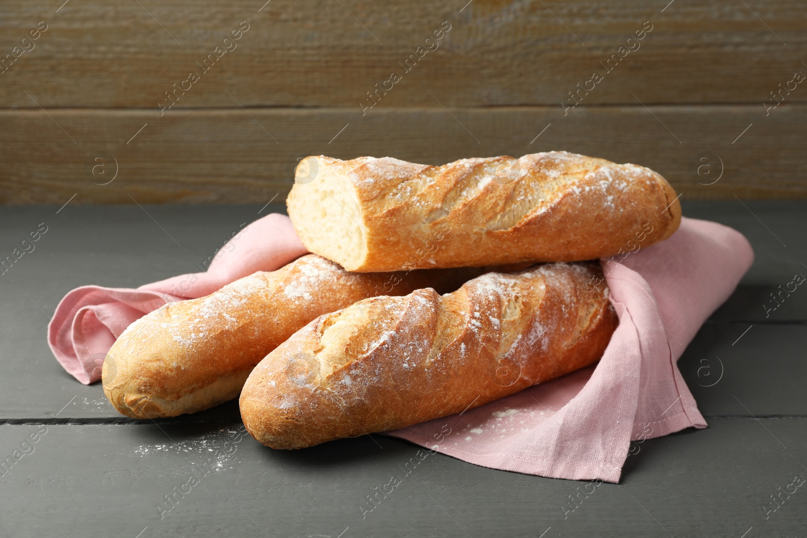 Photo of Cut fresh baguettes on grey wooden table