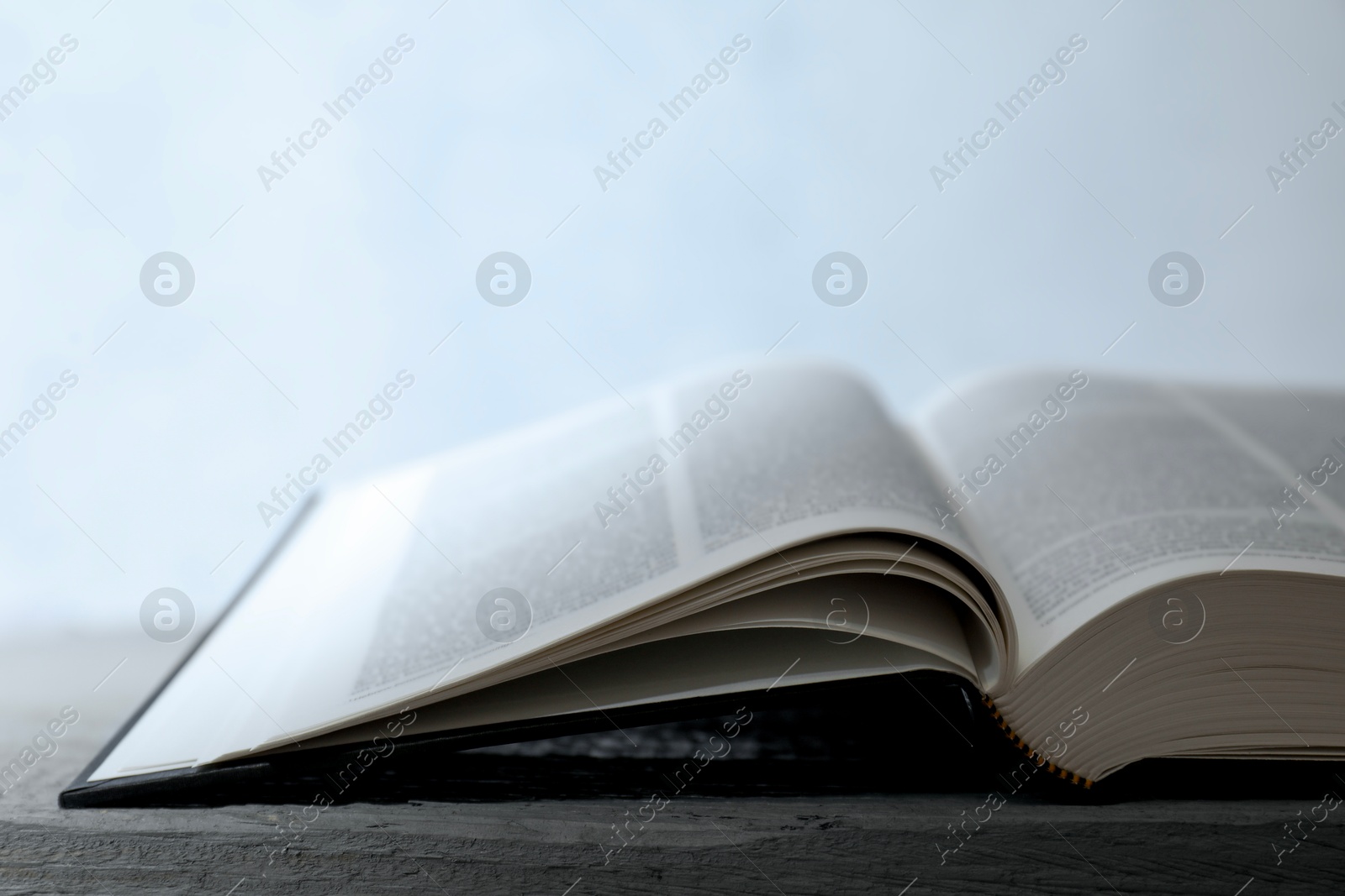 Photo of Open Holy Bible in English language on wooden table, closeup. Space for text