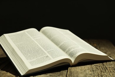 Open Holy Bible in English language on wooden table