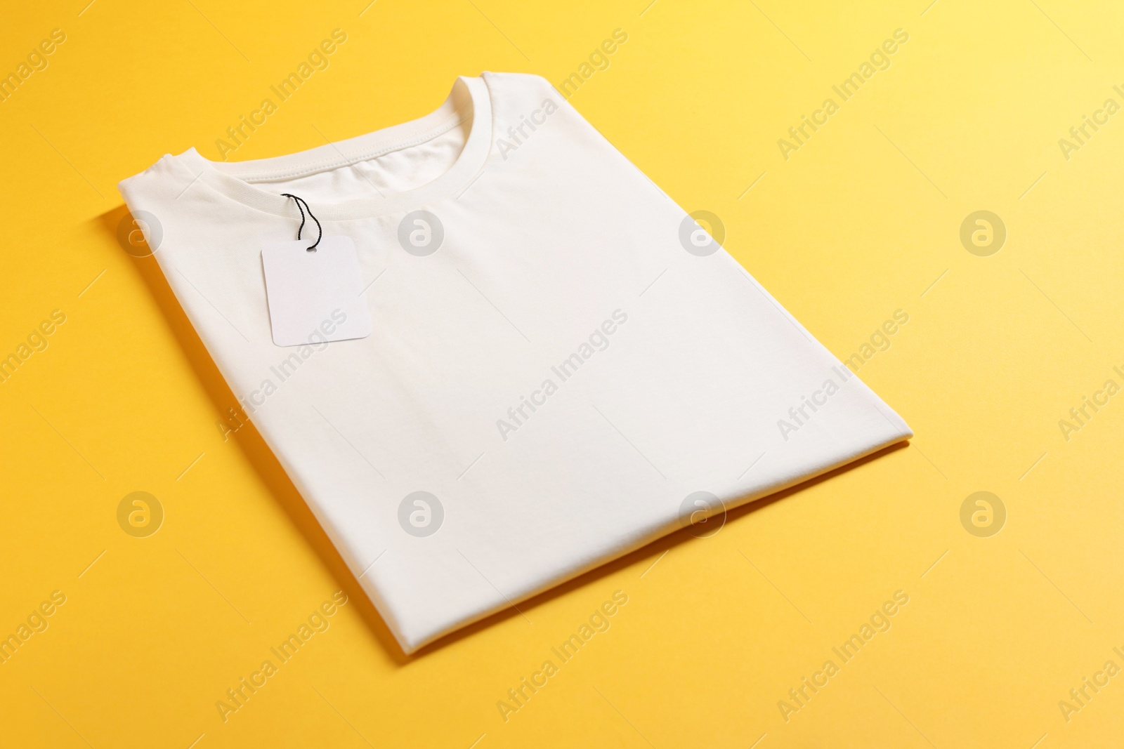 Photo of Blank white t-shirt on yellow background. Mockup for design