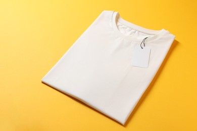 Photo of Blank white t-shirt on yellow background. Mockup for design