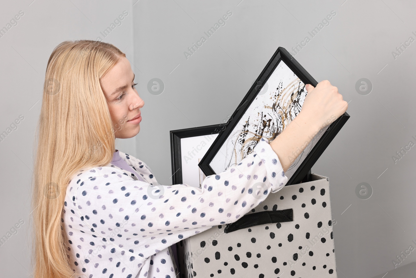 Photo of Female decorator with box of pictures indoors