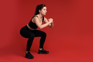 Photo of Woman in sportswear exercising on red background, space for text