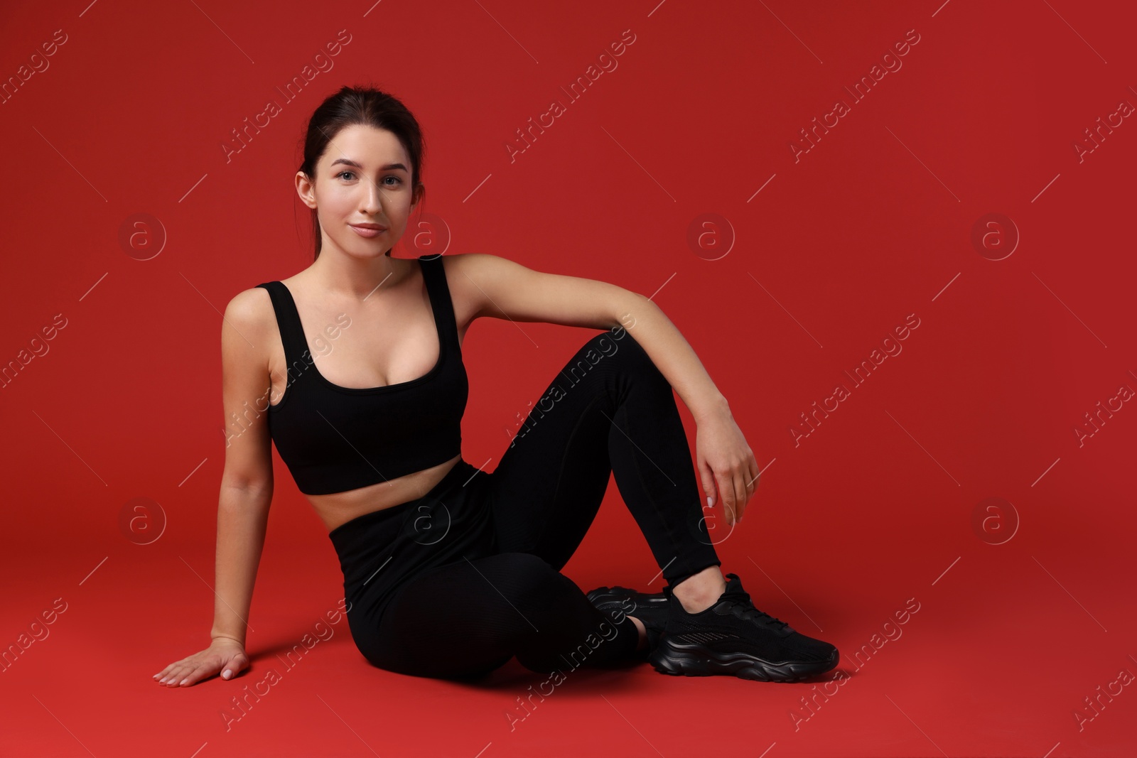 Photo of Portrait of woman in sportswear on red background, space for text