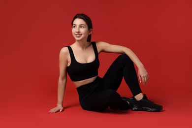 Photo of Portrait of woman in sportswear on red background