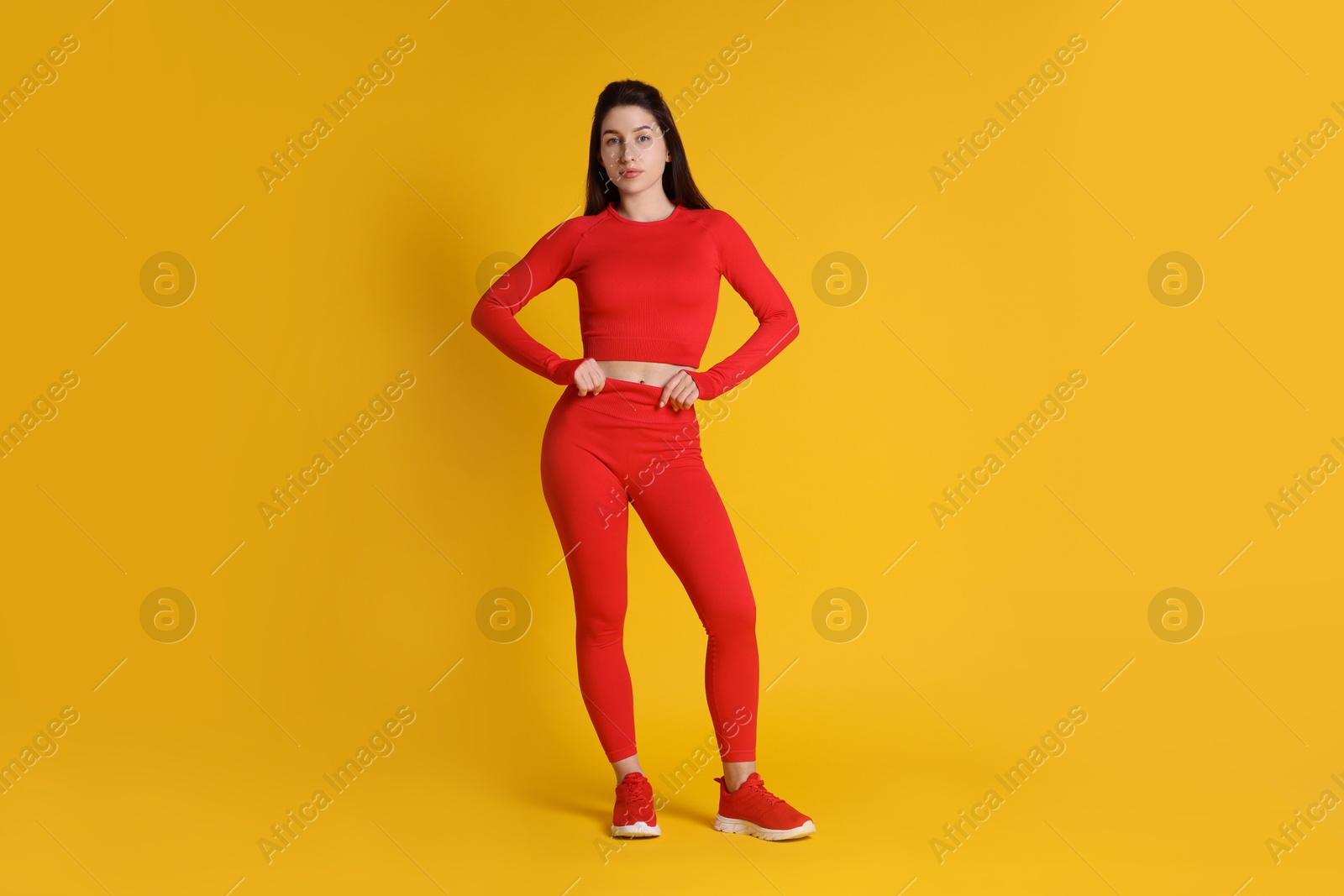 Photo of Portrait of woman in sportswear on orange background