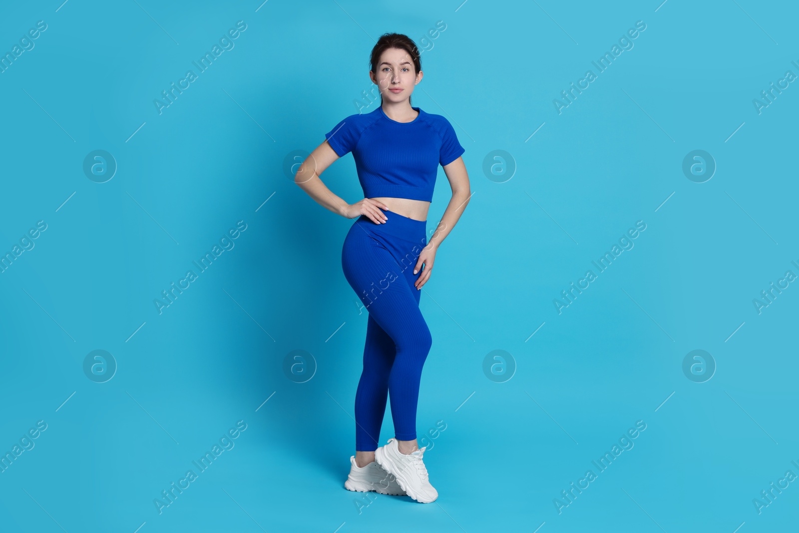 Photo of Portrait of woman in sportswear on light blue background