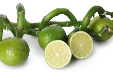 Photo of Fresh limes and bamboo stems isolated on white
