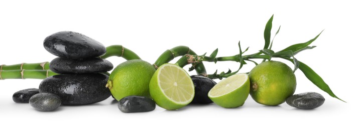Photo of Spa composition with limes, massage stones and bamboo stems isolated on white