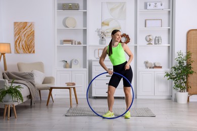 Photo of Smiling woman with hula hoop at home