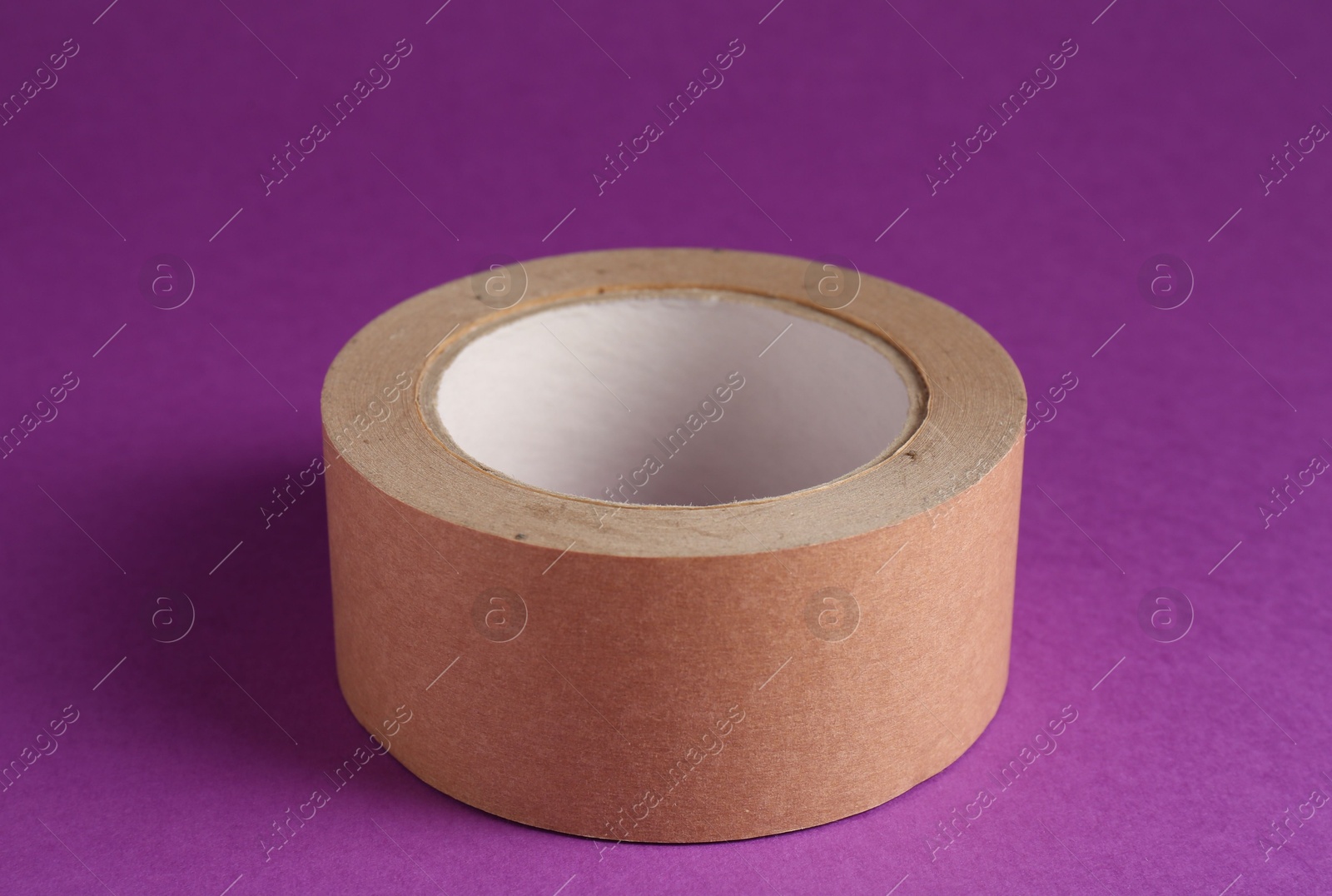 Photo of Roll of masking tape on violet background