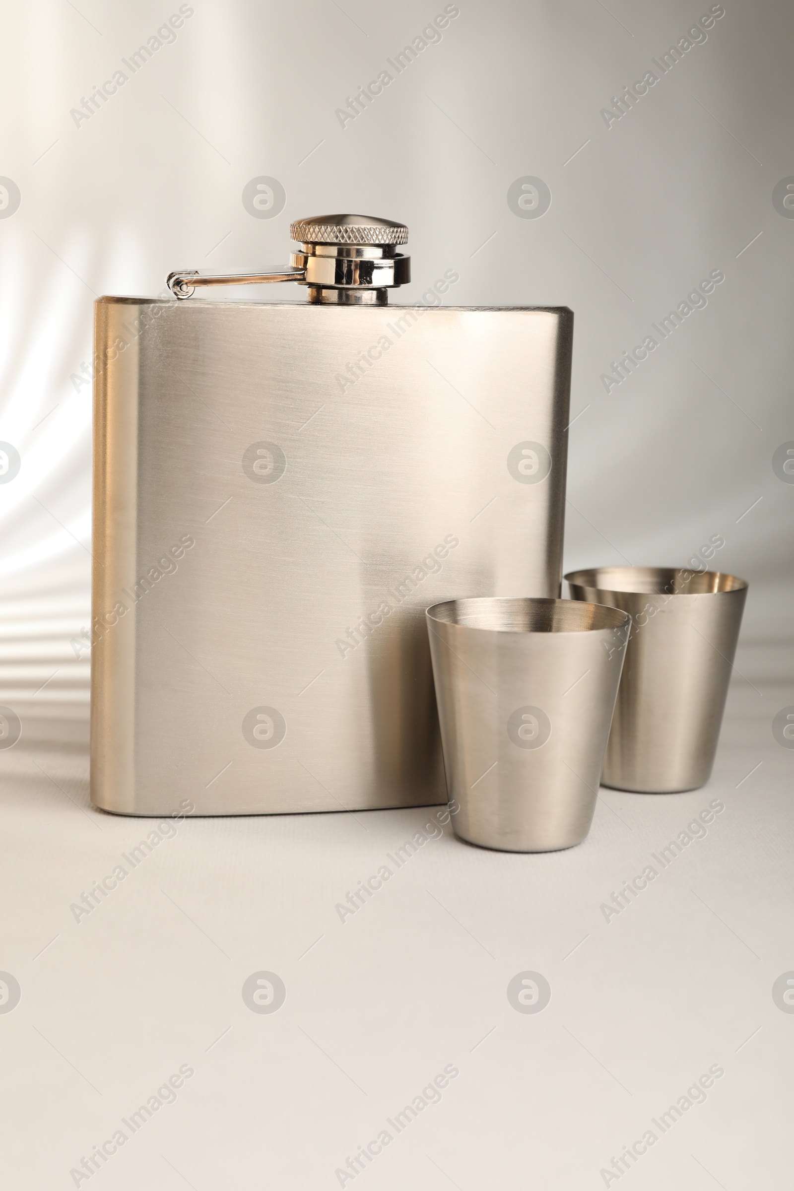 Photo of Hip flask and cups on light table