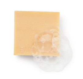 Photo of Beige soap with foam on white background, top view