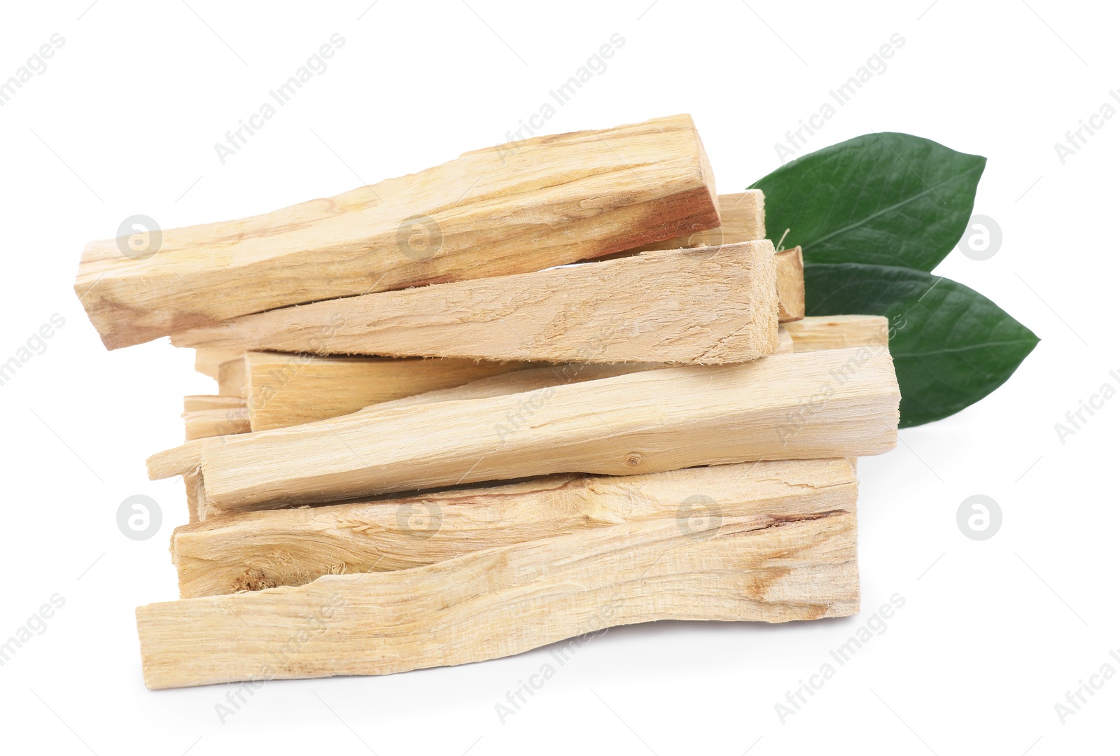 Photo of Pile of palo santo sticks and green leaves on white background