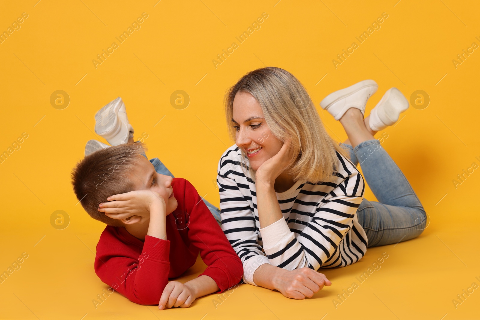 Photo of Happy mother and son on orange background