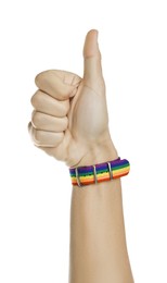 Photo of Man with bracelet in colors of LGBT flag showing thumbs up on white background, closeup