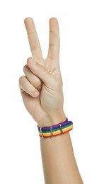 Photo of Man with bracelet in colors of LGBT flag showing peace sign on white background, closeup