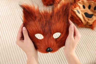 Photo of Quadrobics. Woman with furry fox mask near sofa, closeup