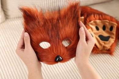 Photo of Quadrobics. Woman with furry fox mask near sofa, closeup