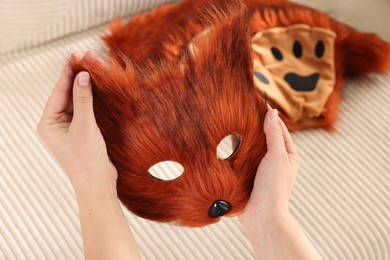 Photo of Quadrobics. Woman with furry fox mask near sofa, closeup