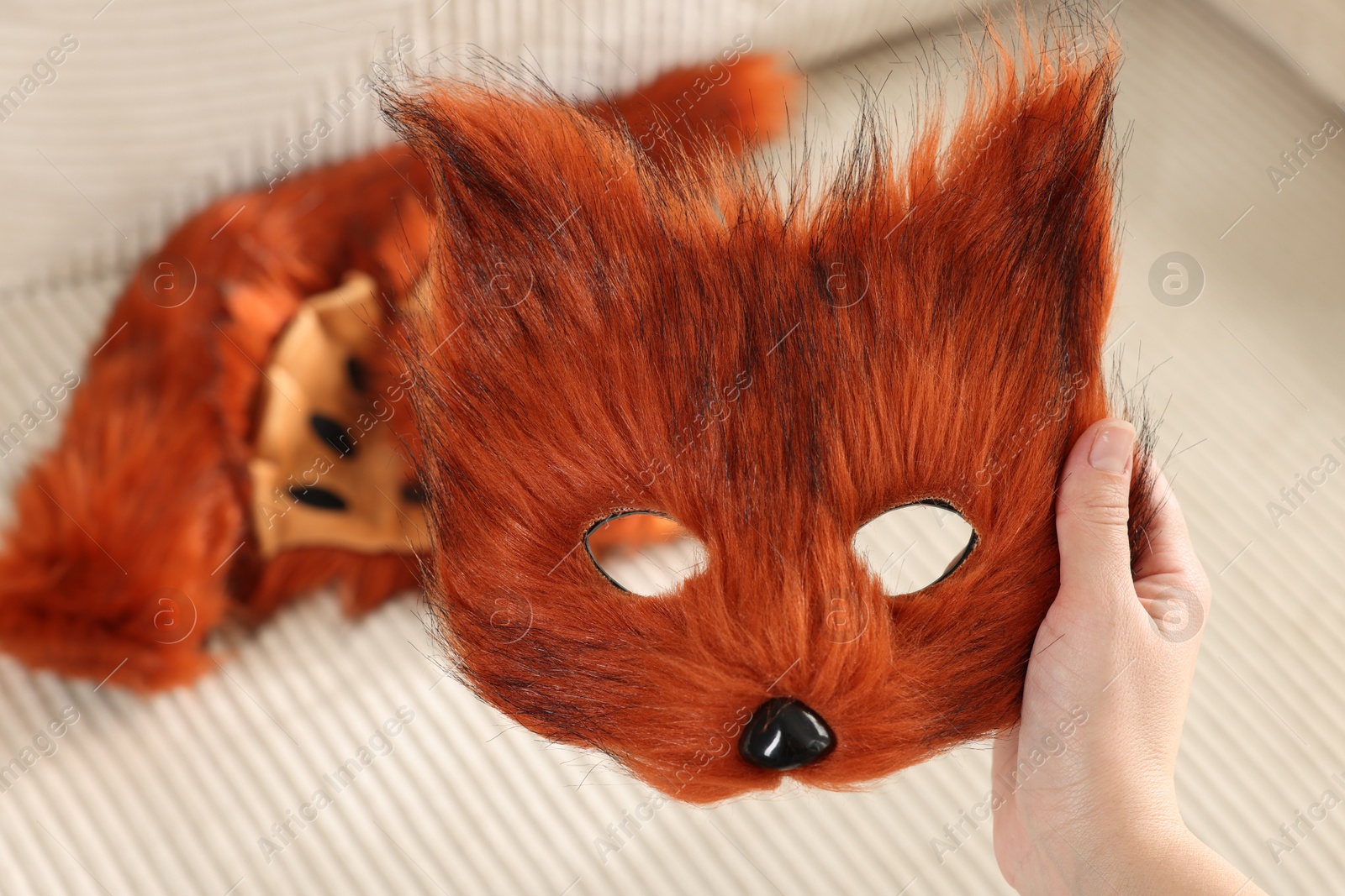 Photo of Quadrobics. Woman with furry fox mask near sofa, closeup