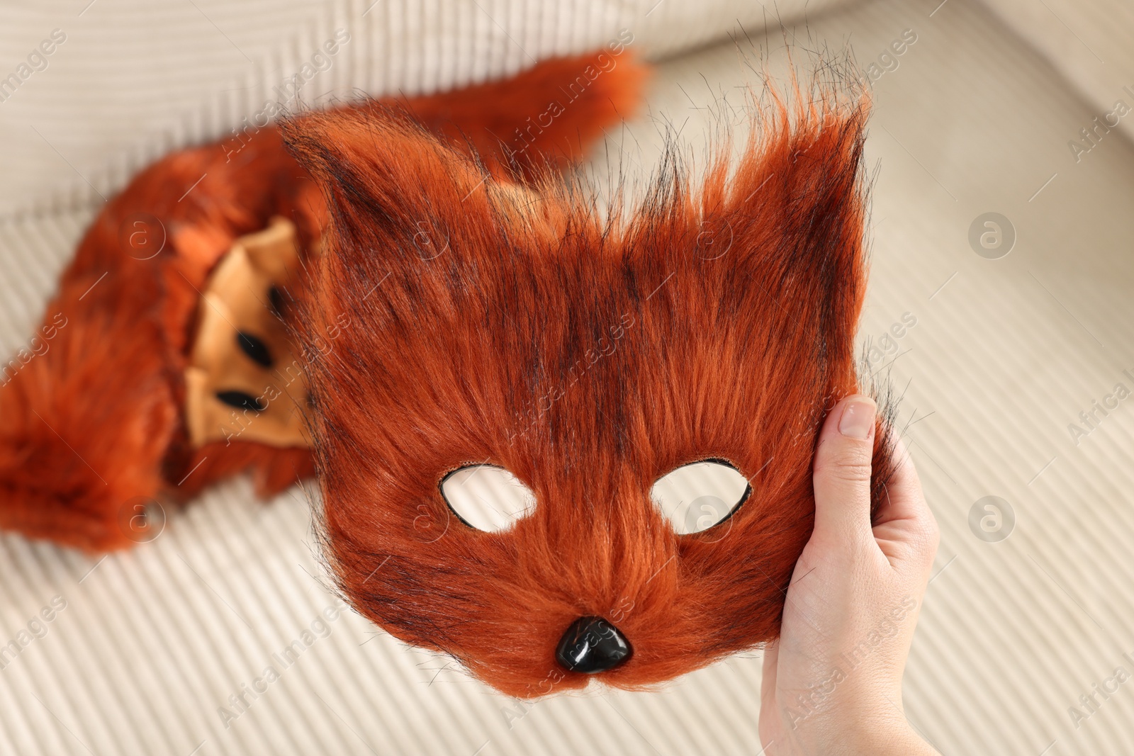 Photo of Quadrobics. Woman with furry fox mask near sofa, closeup