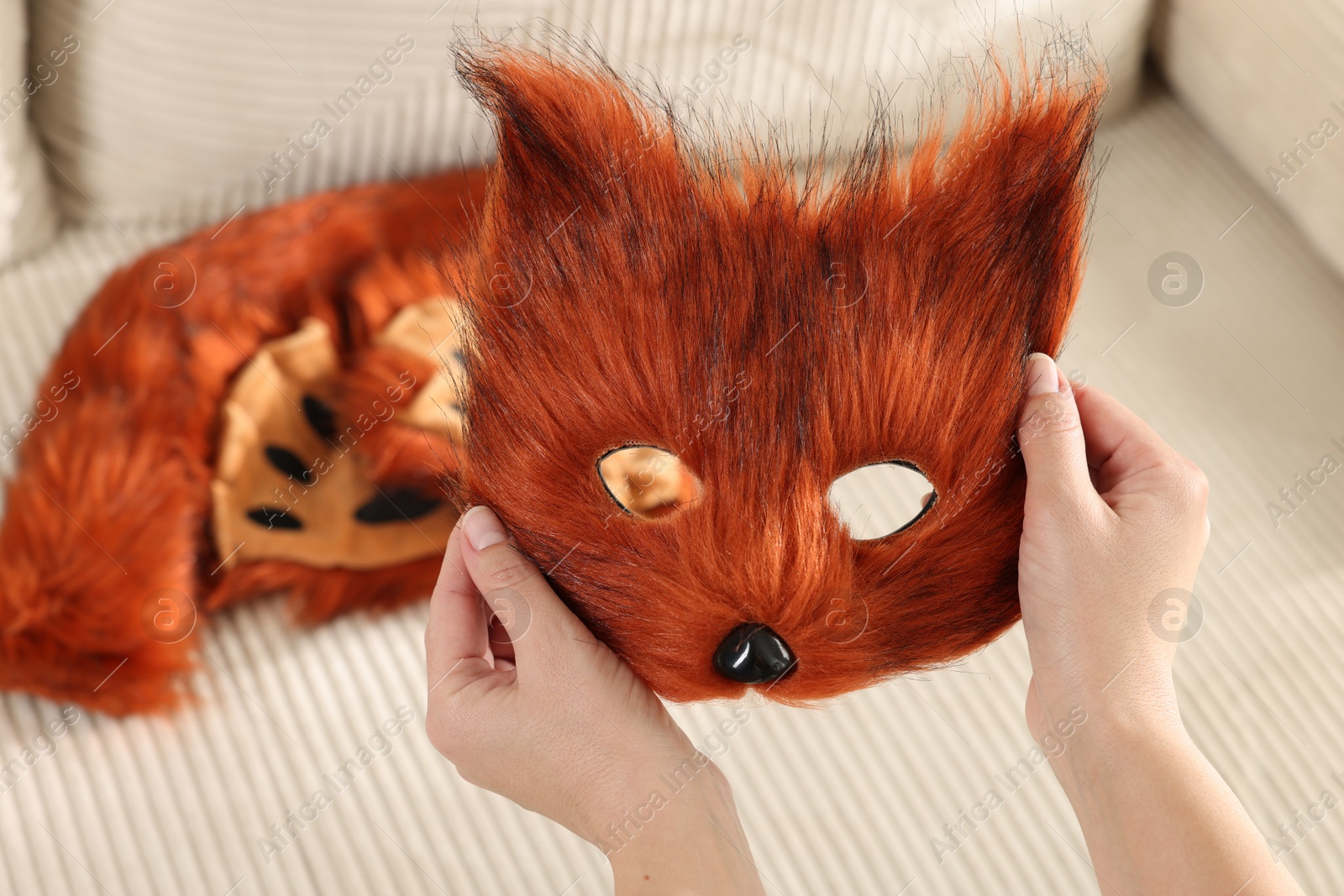 Photo of Quadrobics. Woman with furry fox mask near sofa, closeup